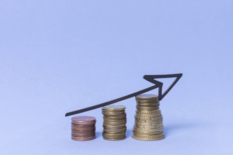 Biomasa para todos vista frontal de pilas de monedas con una flecha